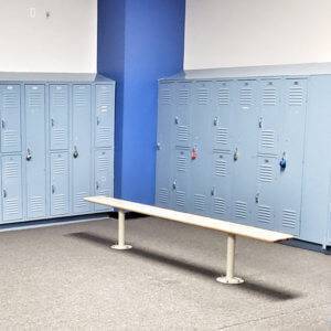 A photo of blue lockers and a bench in an Elite Edge locker room.