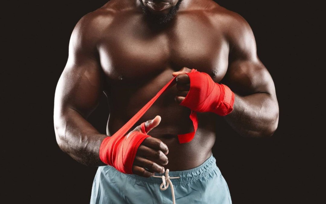 Professional black sportsman rolling boxing wraps over wrists